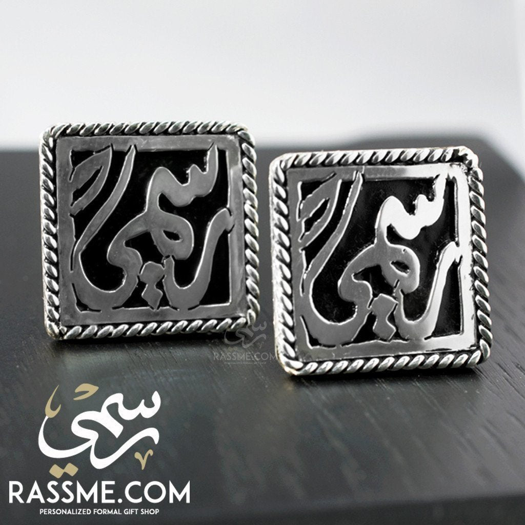 Square silver cufflinks with raised Arabic calligraphy and decorative borders.