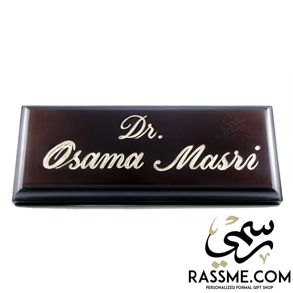 Dark wooden desk name sign engraved in English
