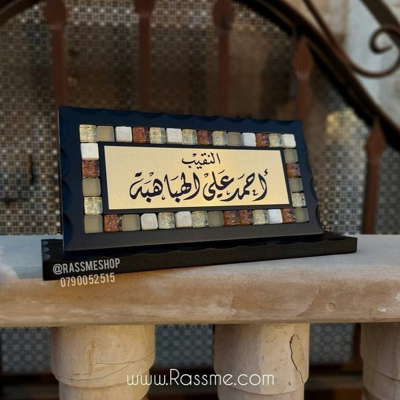 Mosaic desk name sign with Arabic calligraphy and a black wooden base