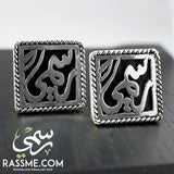 Square silver cufflinks with raised Arabic calligraphy and decorative borders.
