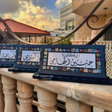 Dark mosaic desk name signs with Arabic calligraphy in black wooden frames
