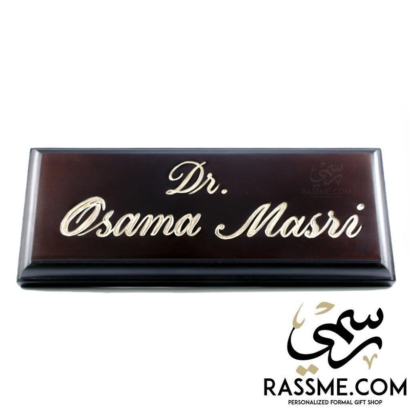 Dark wooden desk name sign engraved in English