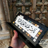 Mother-of-pearl desk name sign with black Arabic calligraphy and mosaic border
